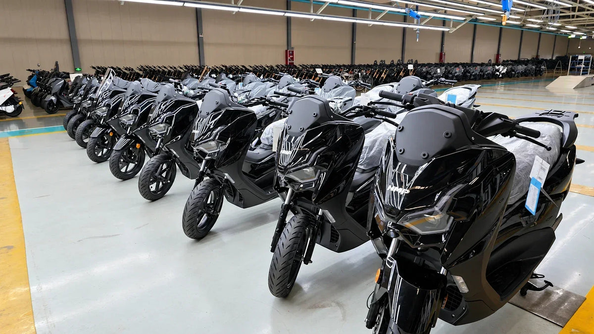 Rows of finished black HMP FLASH electric motorcycles lined up inside the factory