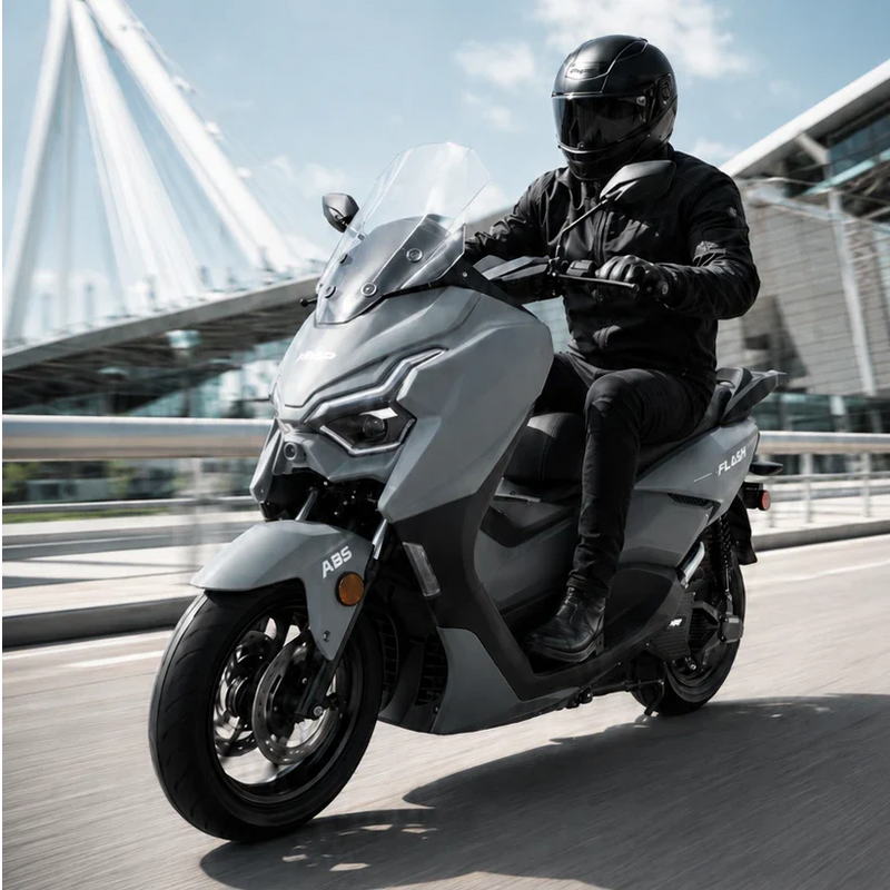 HMP FLASH electric scooter with rider wearing black helmet riding on modern city bridge, high performance electric moped style scooter in urban commuting environment, motion blur, premium commercial photography.